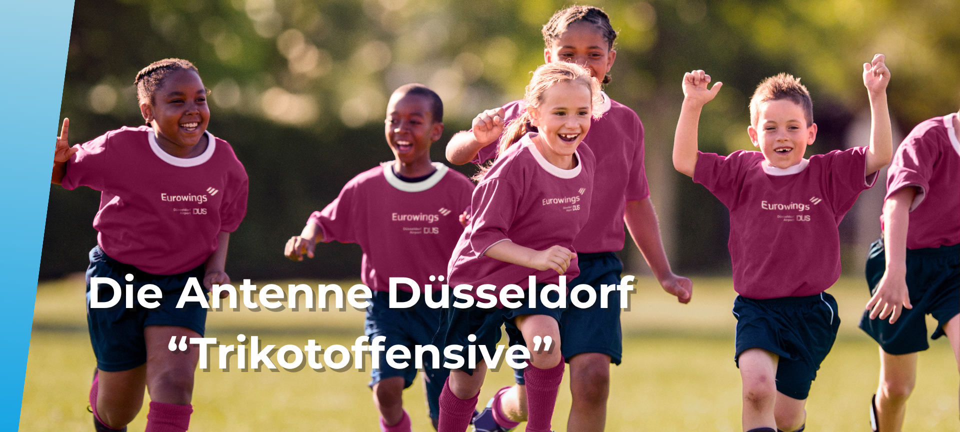 Eine Mannschaft von Kindern in Sportbekleidung jubelt auf dem Sportplatz.