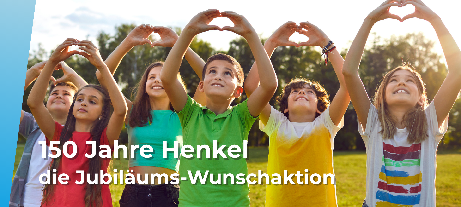 Kinder stehen auf einer Wiese und formen mit ihren Händen Herzen, die sie in die Luft strecken.