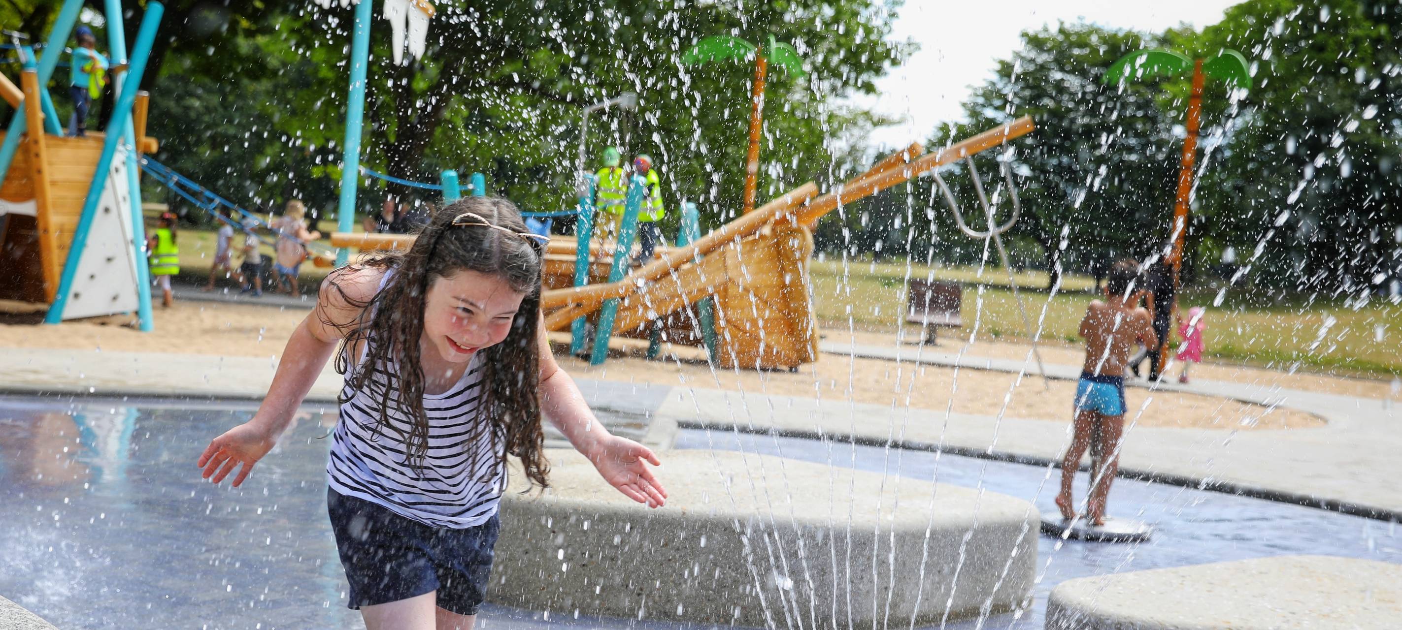 Ein Mädchen spielt auf dem Wasserspielplatz an der Emmastraße im Volksgarten.