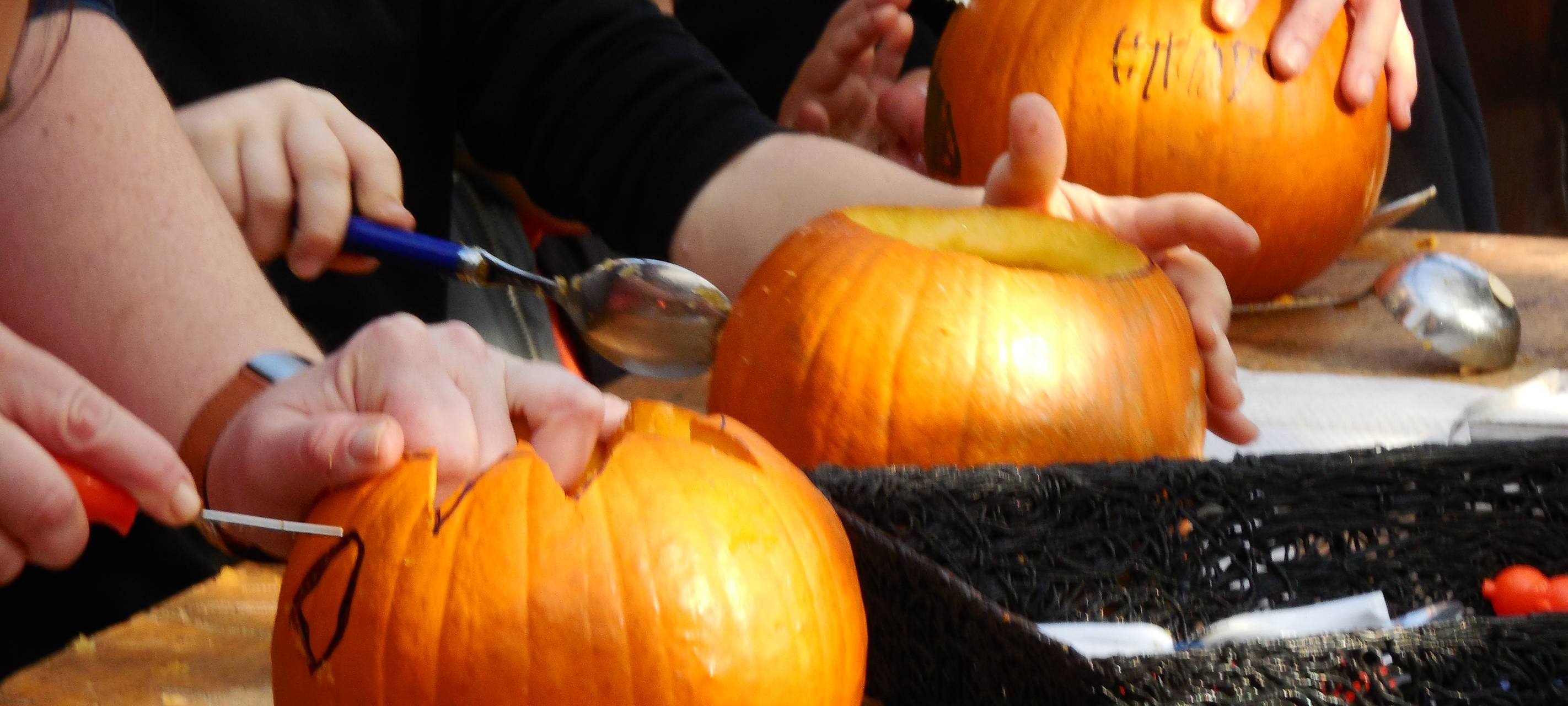 Kinder beim Schnitzen von Kürbissen.