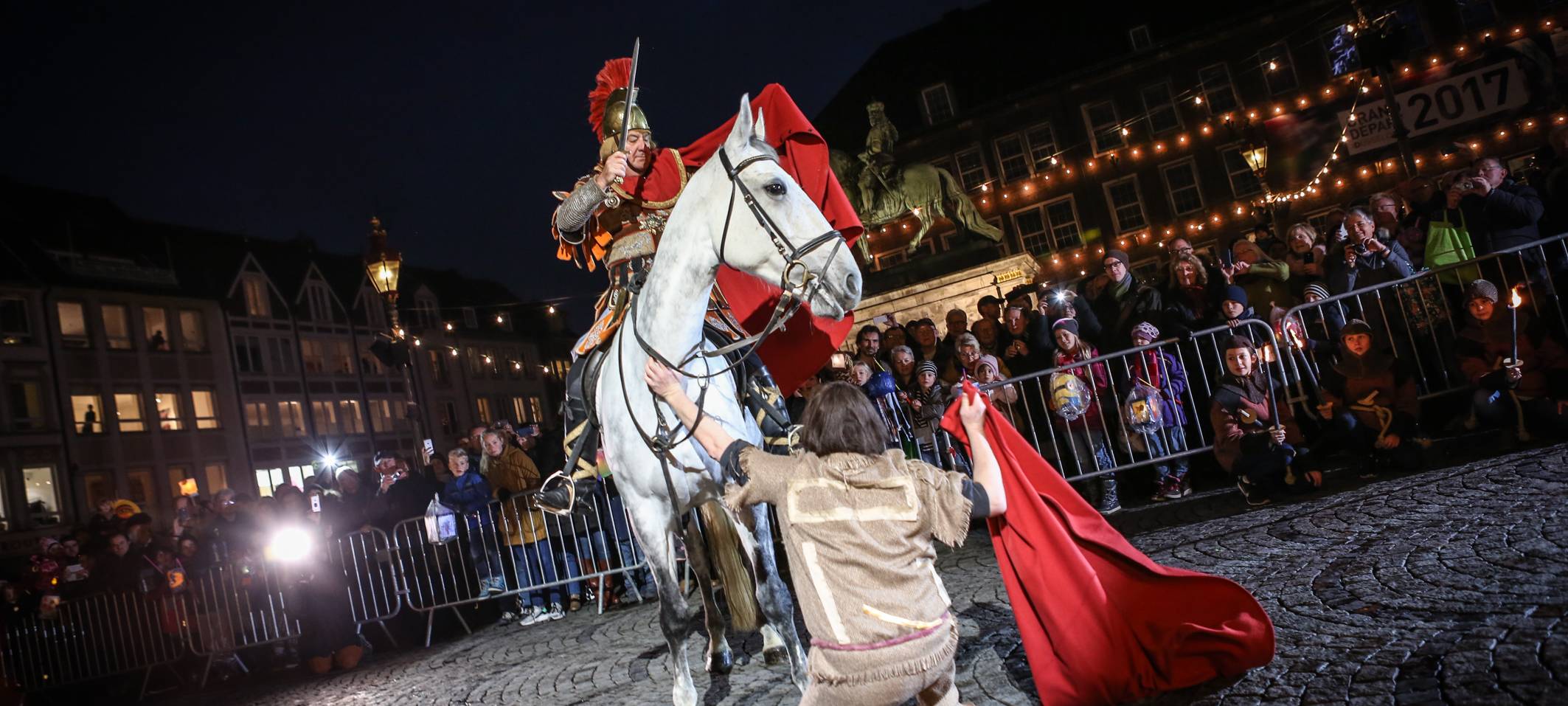 St. Martin bei der Mantelteilung in der Altstadt. Ein Bettler bekommt Teile seines Mantels.