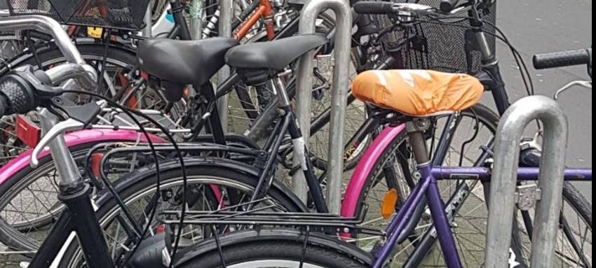 Mehrere Fahrräder stehen an einem Fahrradständer an einer Straße in Düsseldorf.