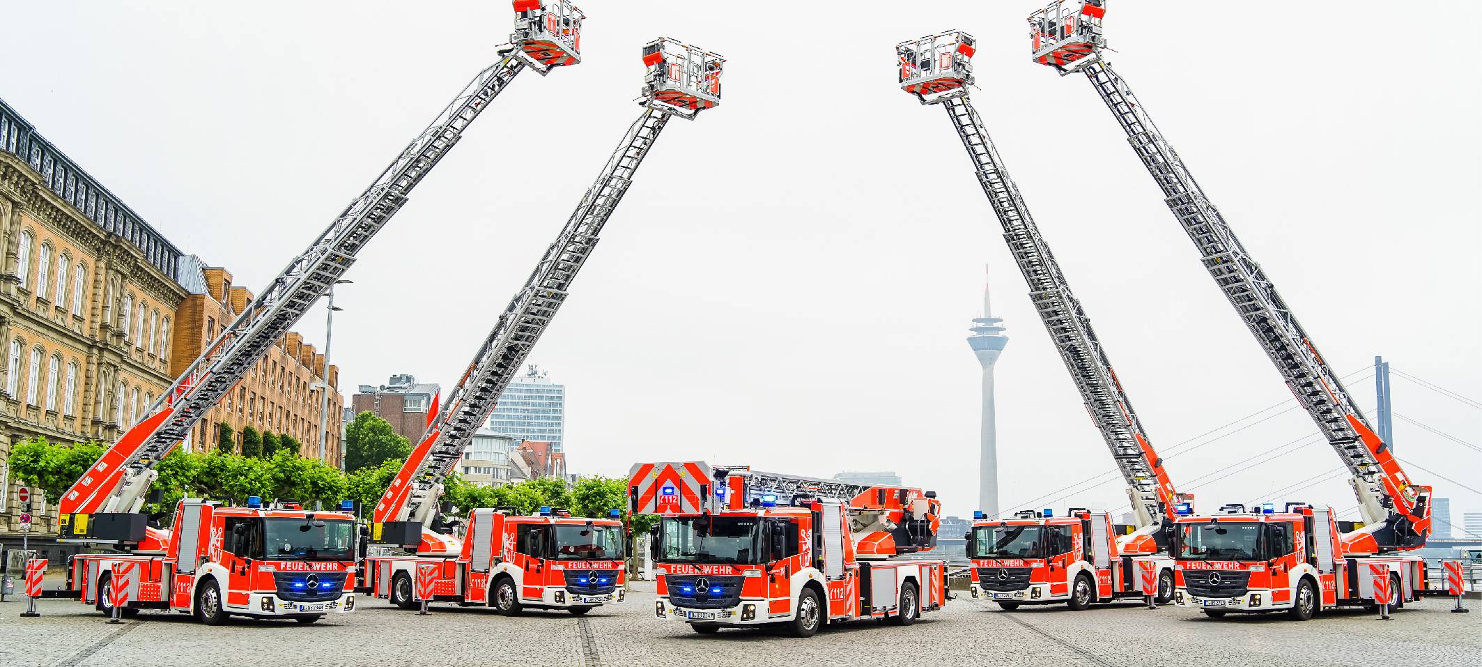 Mehrere Feuerwehrwagen der Düsseldorfer Feuerwehr auf dem Burgplatz. Die Leitern der Wagen sind ausgefahren.
