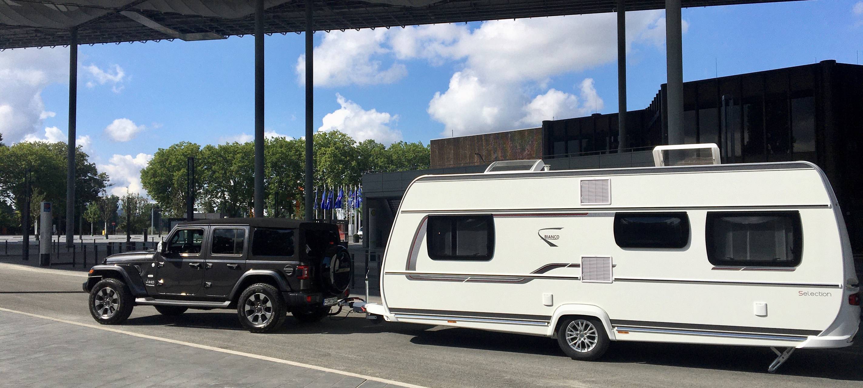 Ein Wohnwagen steht vor dem Eingang der Messe "Caravan Salon".