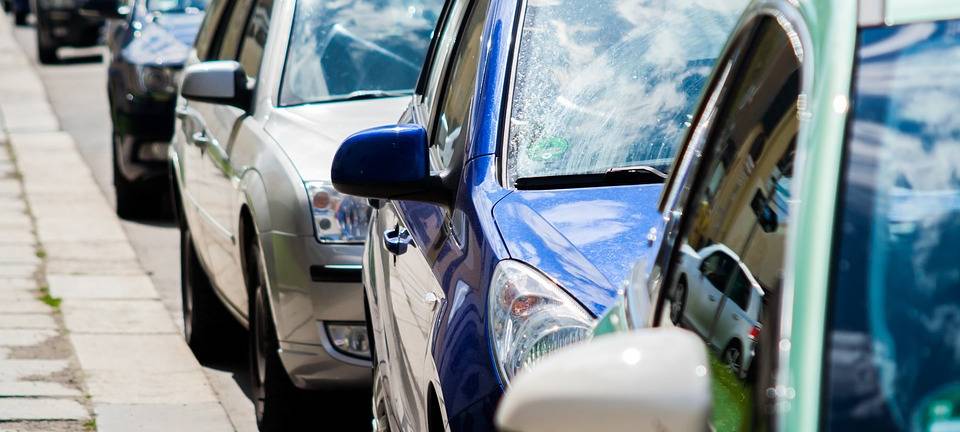 Mehrere Autos stehen hintereinander geparkt am Straßenrand.