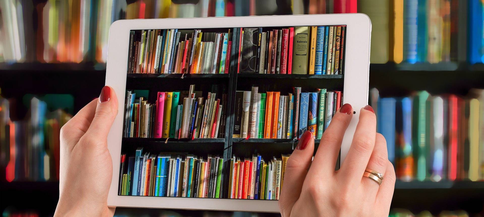 Ein Tablet, mit dem ein Bücherregal fotografiert wird.