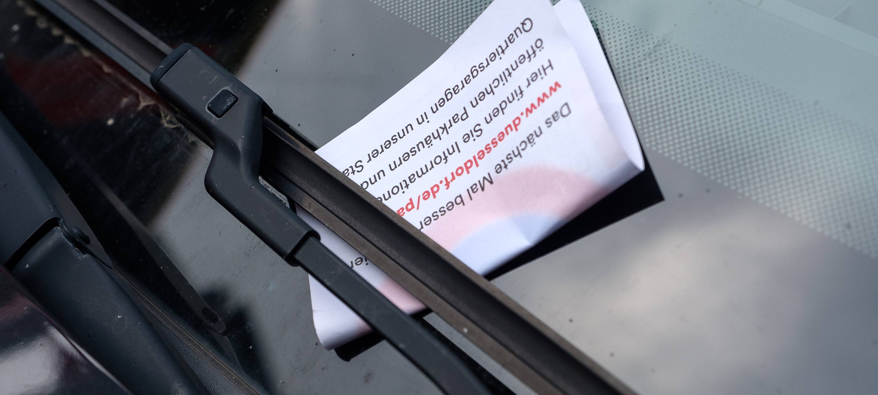 Ein Knöllchen unter einem Scheibenwischer.