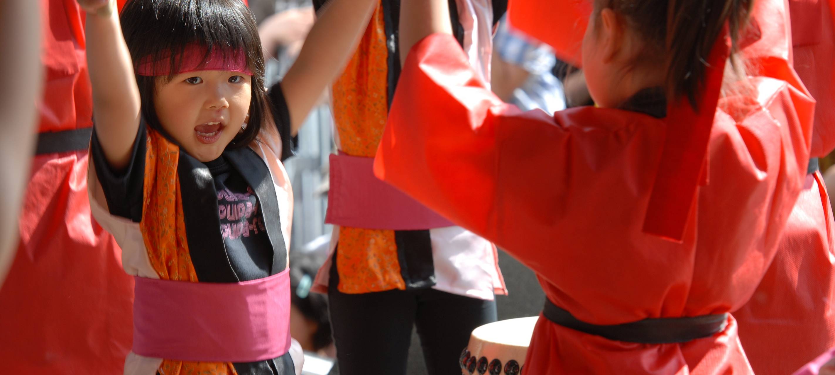 Zwei Kinder schlagen am Japan-Tag auf eine Trommel und tragen festliche Gewänder.