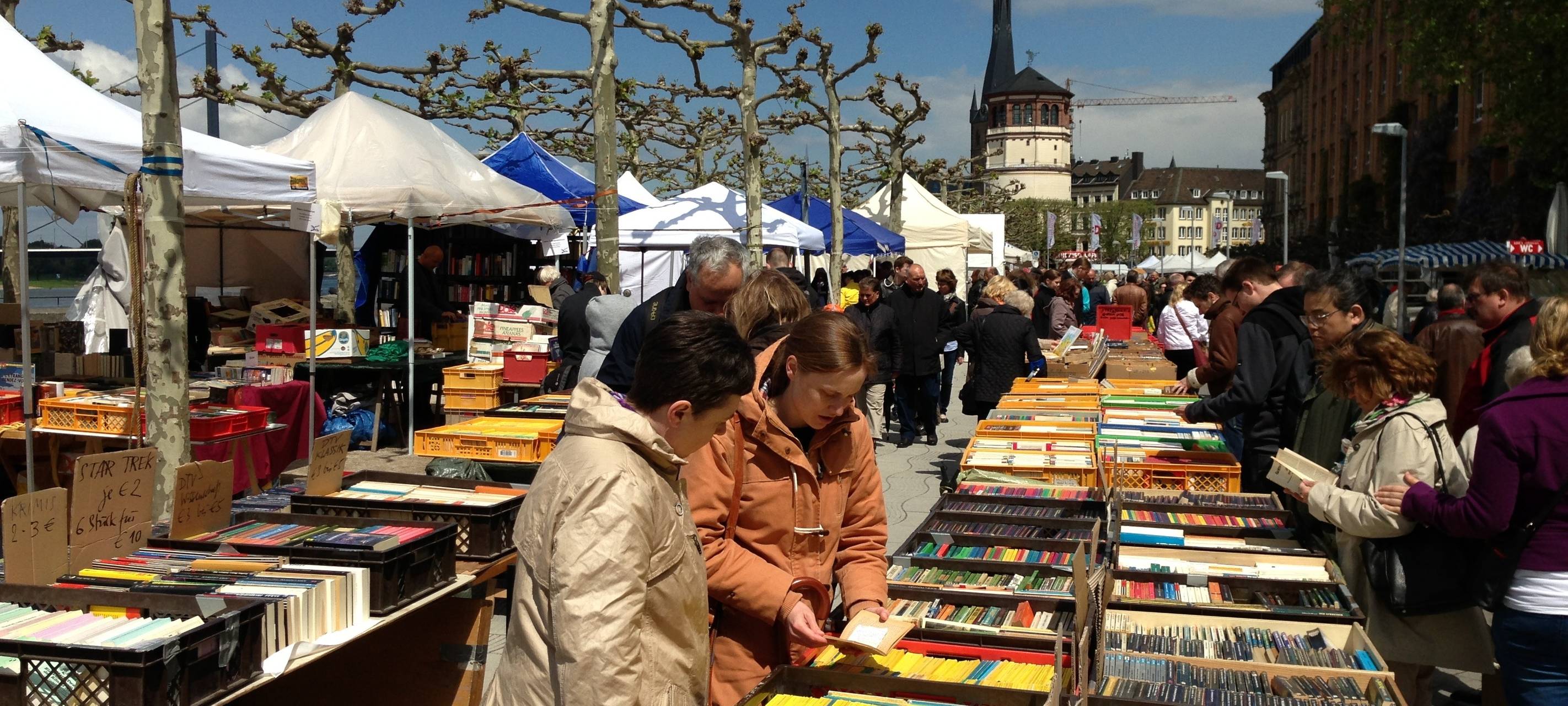Eine belebte Büchermeile am Rheinufer zwischen dem Alten Hafen und dem Burgplatz.