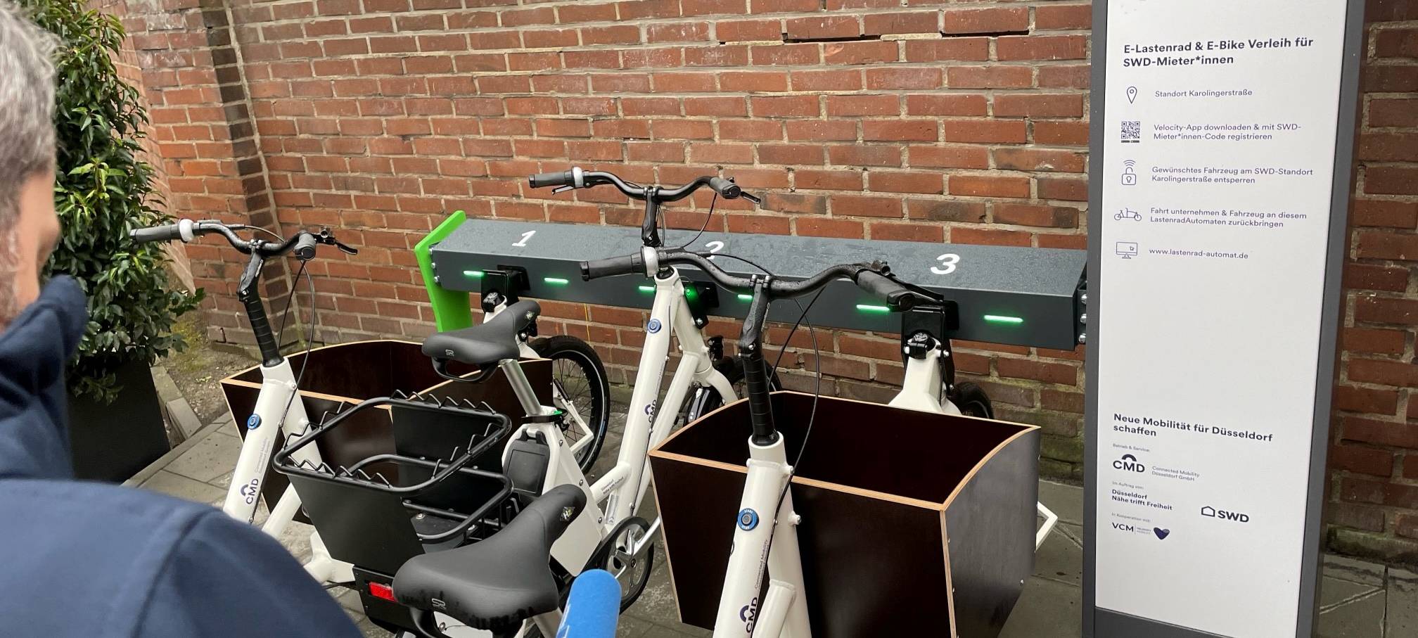 Ein Mann steht vor einem Lastenrad-Automaten.
