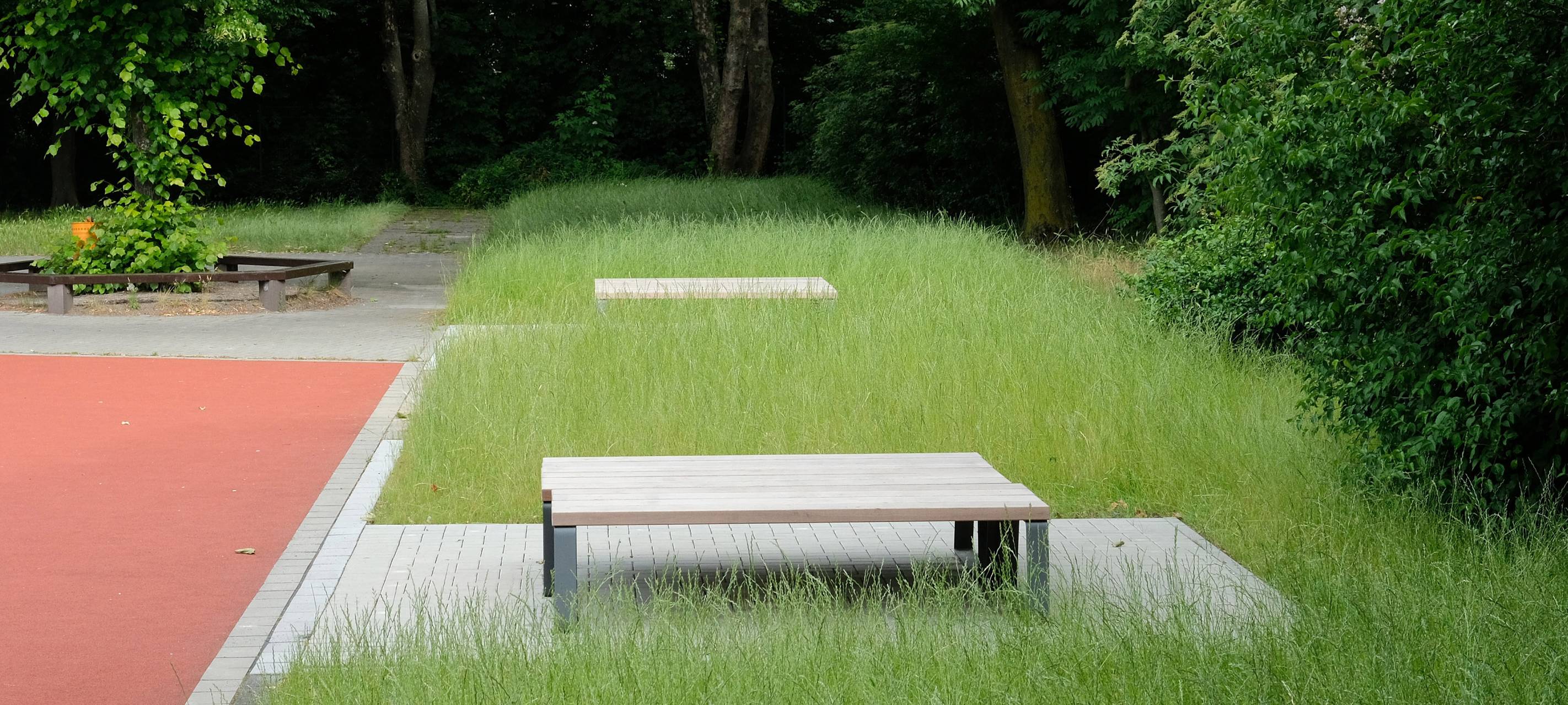 Grüne Rasenfläche mit einer grauen Sitzfläche