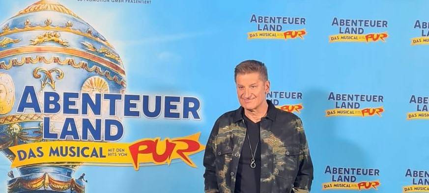 Pur-Sänger Hartmut Engler vor einer Werbewand für sein Musical.