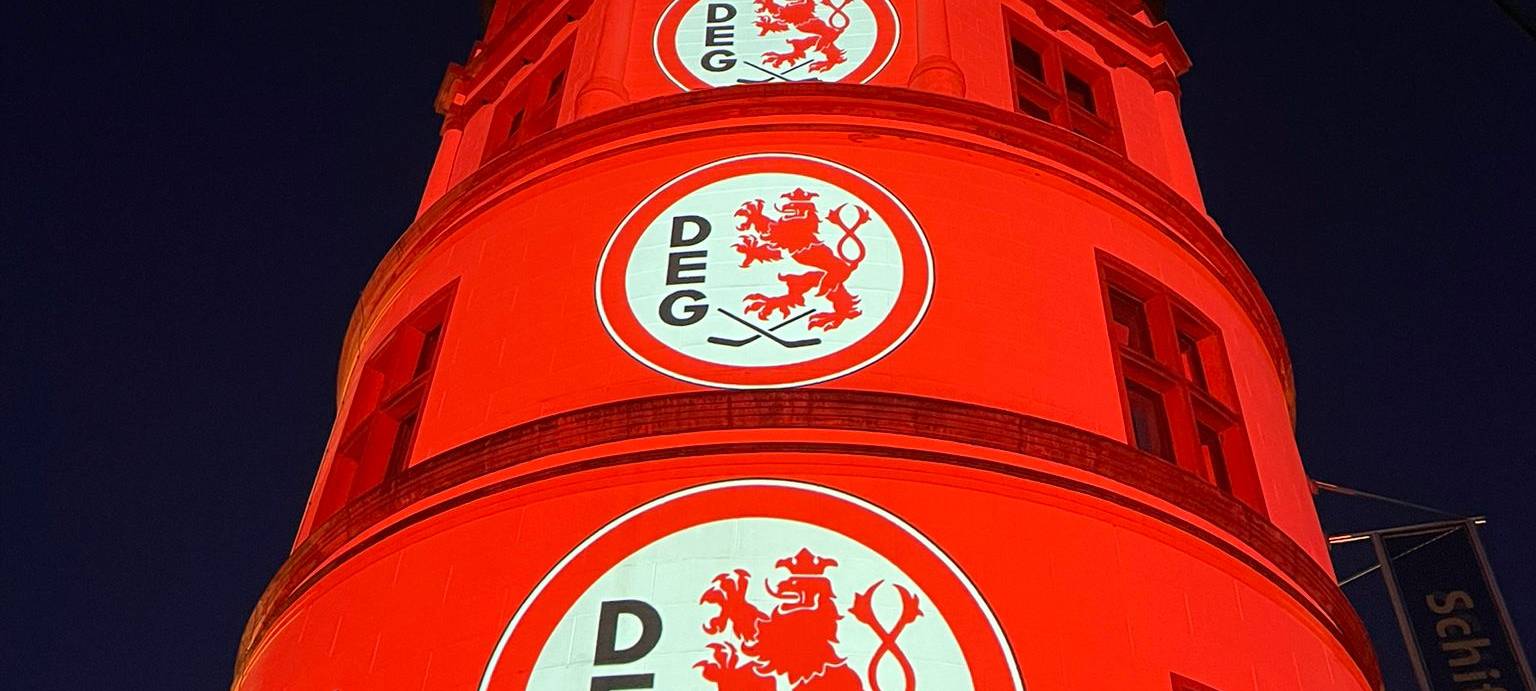 Der Schlossturm an Burgplatz wird mit Licht und DEG-Logos angestrahlt.