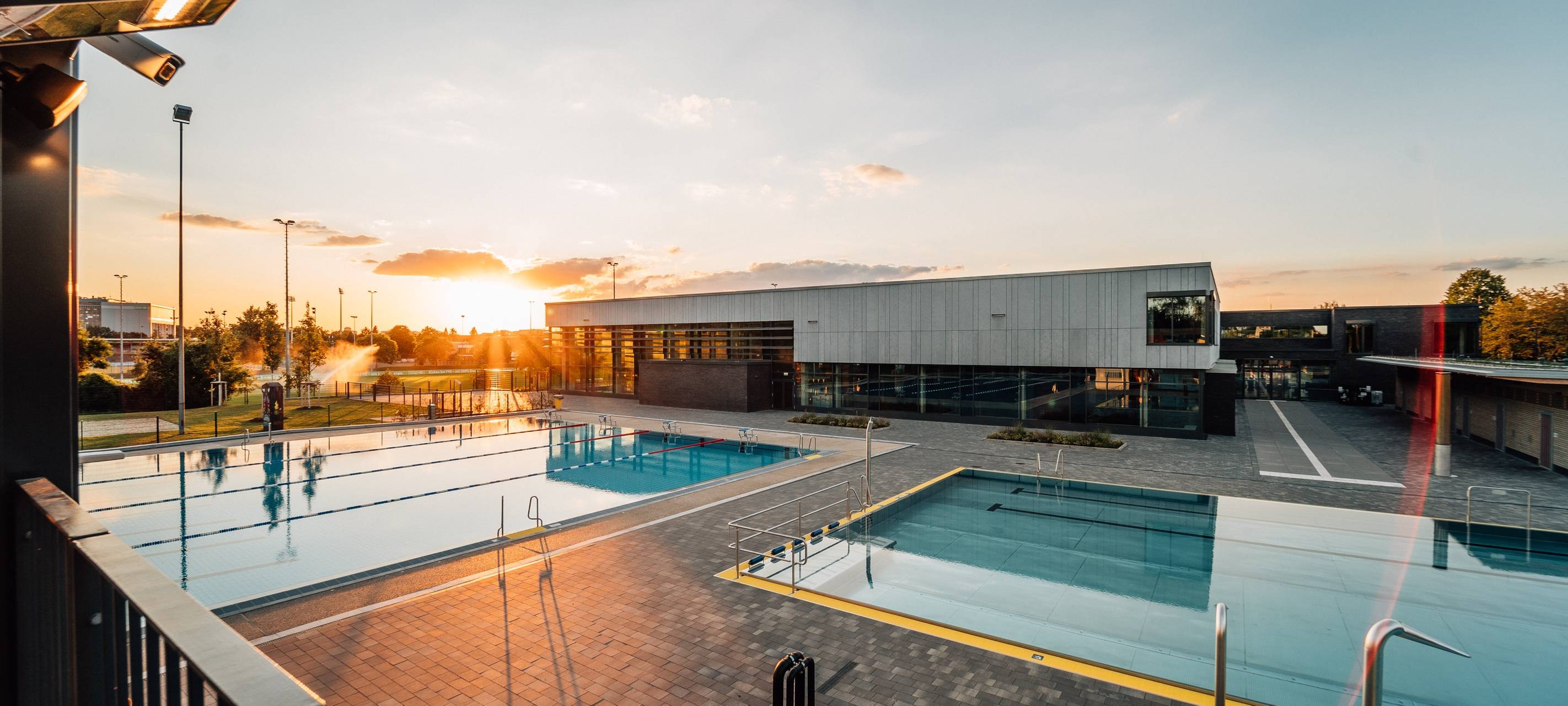 Das Allwetterbad in Flingern mit Schwimmbecken und Sonnenuntergang.