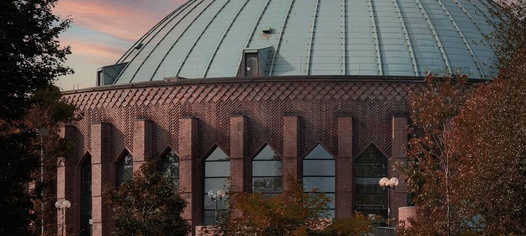 Außenansicht der Düsseldorfer Tonhalle. Der Sonnenuntergang sorgt für schöne Farben im Hintergrund.