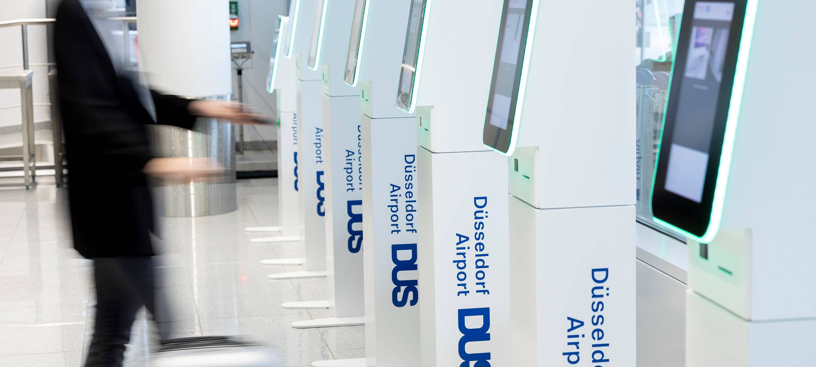 Gepäckschalter am Düsseldorfer Flughafen. Ein Passagier checkt sein Gepäck selber ein.