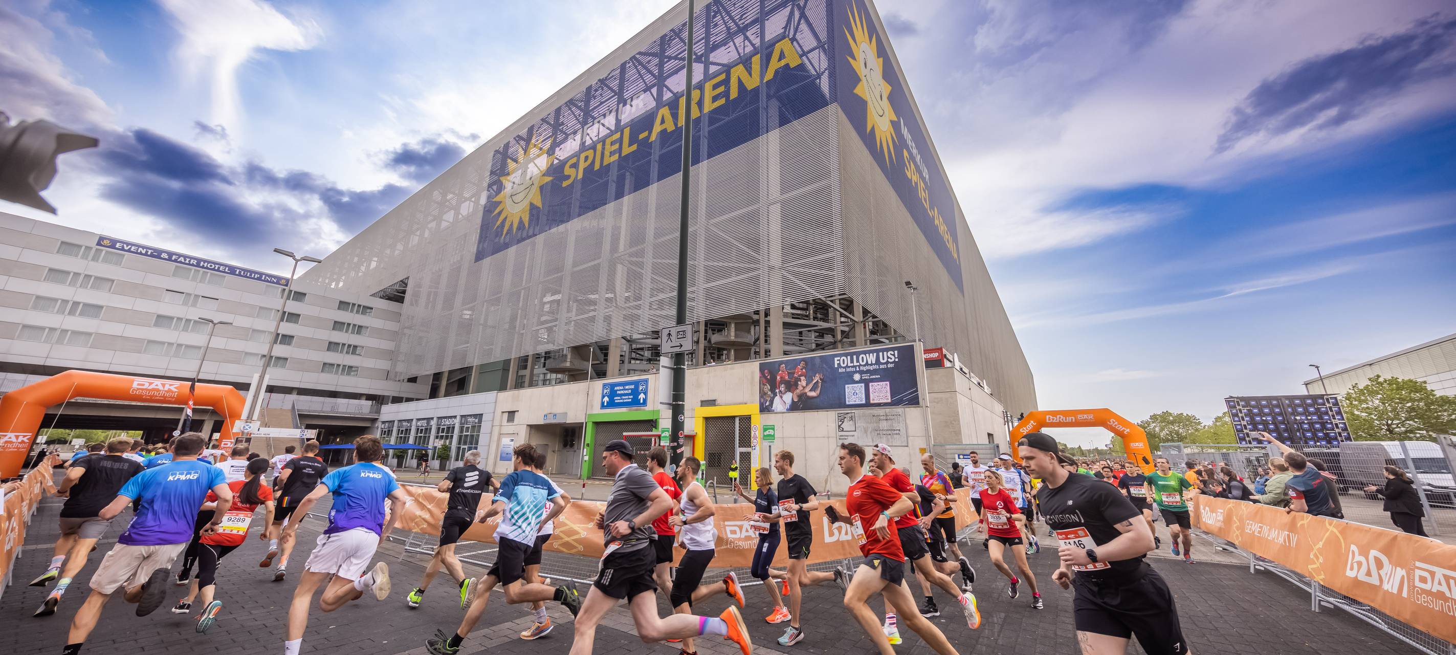 Männer und Frauen laufen um die Merkur Spiel-Arena.
