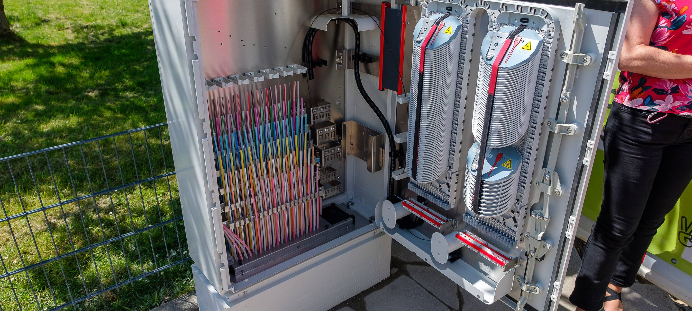 Ein geöffneter Kasten mit Kabeln. Es handelt sich um Glasfaserkabel.