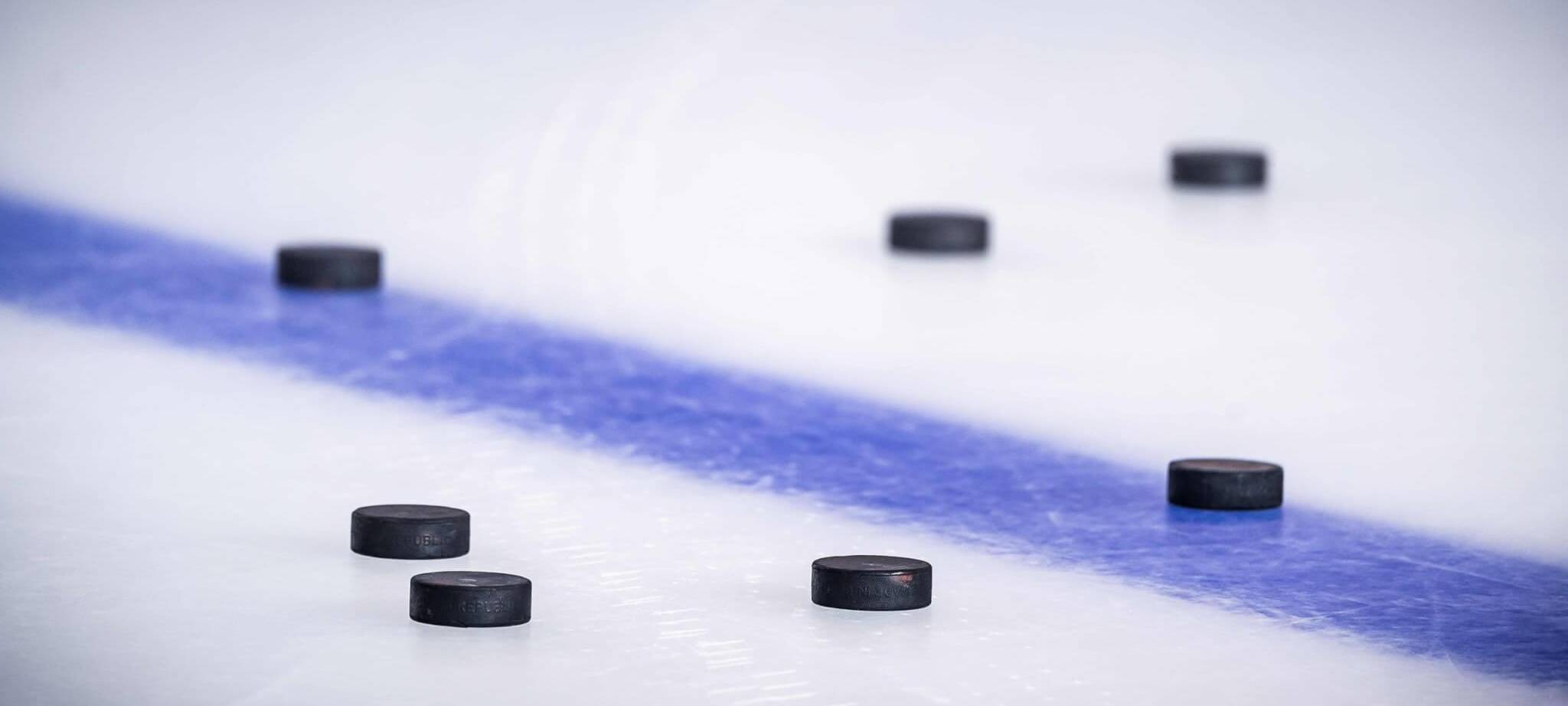 Eisfläche mit blauer Linie und Pucks, Deutschland-Cup könnte nach Düsseldorf kommen