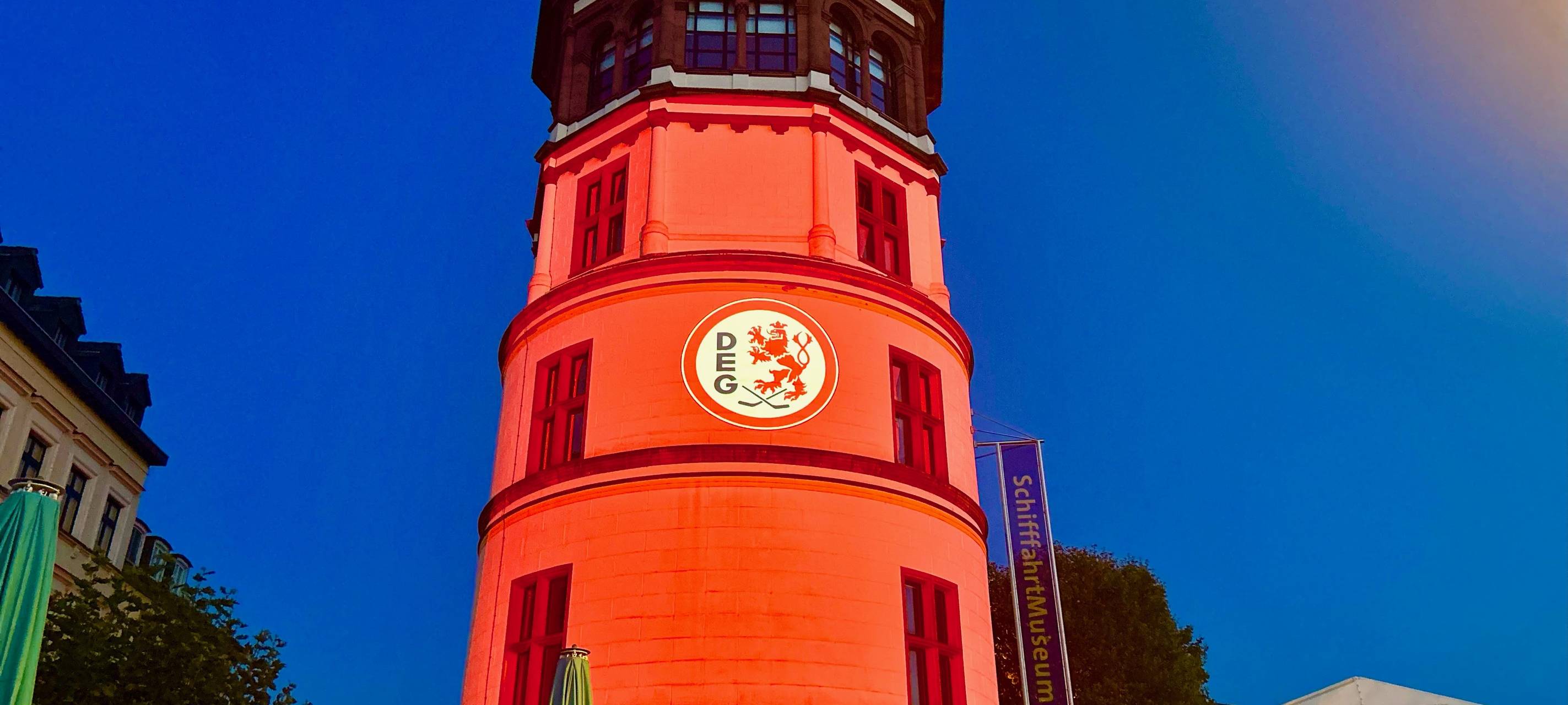Der Schlossturm in Düsseldorf. Darauf ein projiziertes Logo der Düsseldorfer EG.