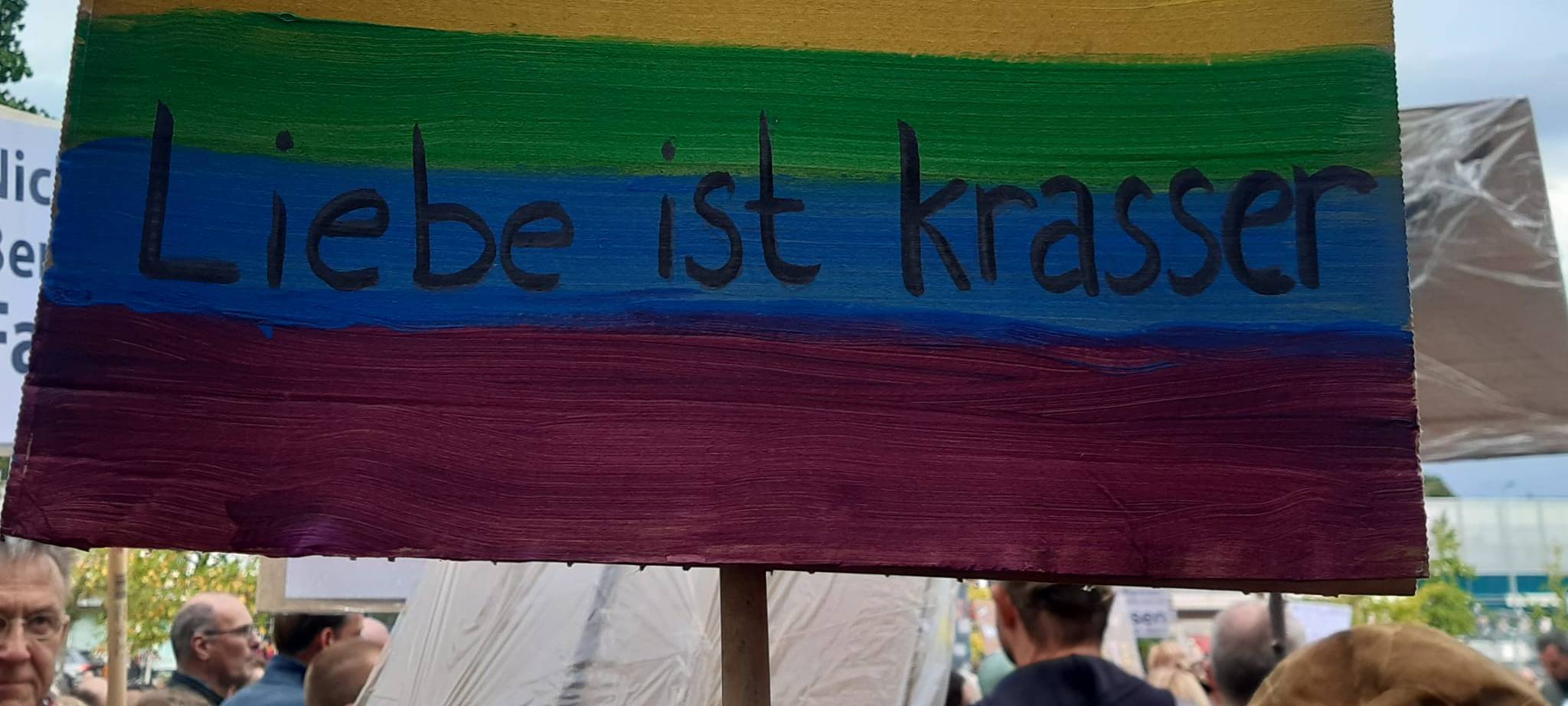 Ein Demo-Plakat in Regenbogenfarben mit dem Satz "Hass ist krass - Liebe ist krasser".