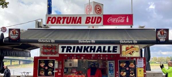 Eine Kundin steht vor dem Fortuna-Büdchen am Rhein.