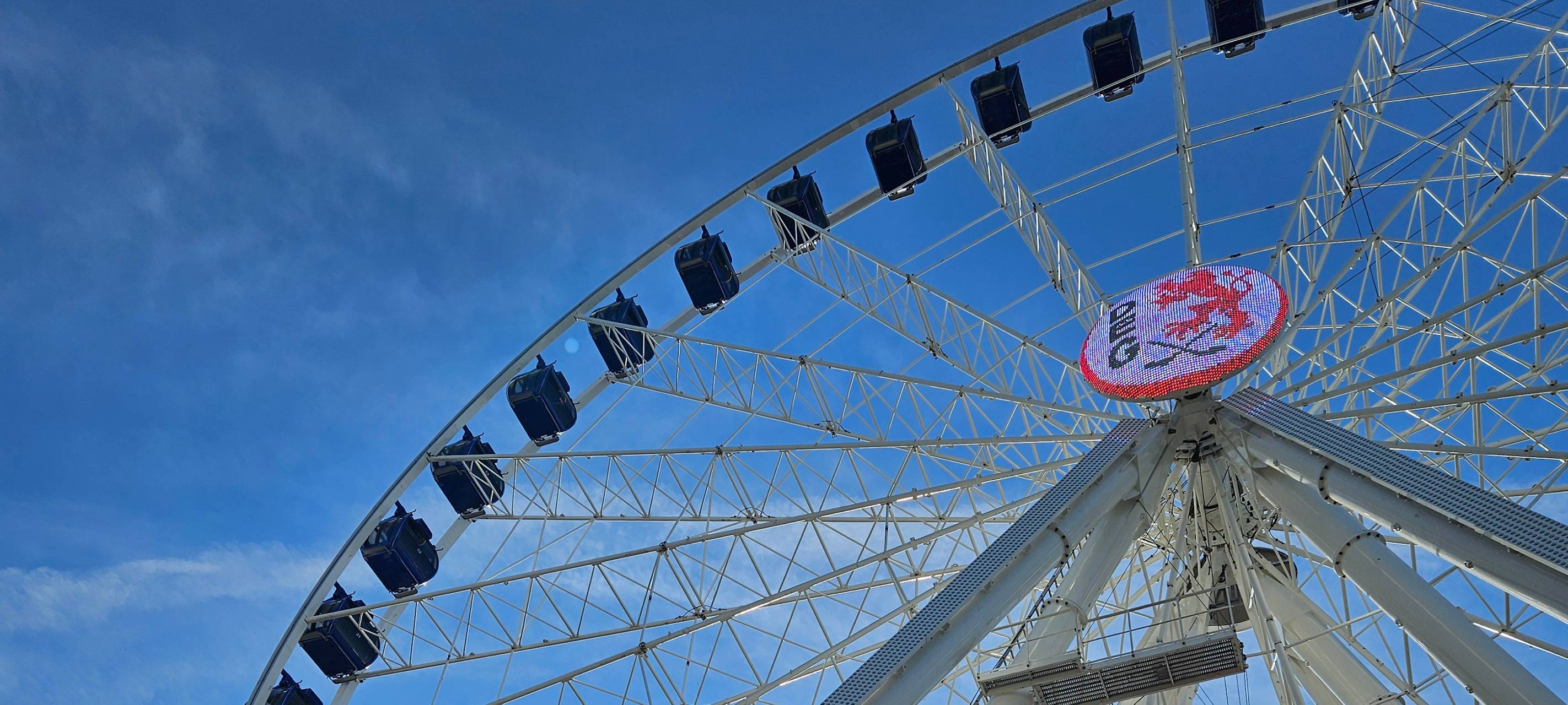 Das Riesenrad auf dem Burgplatz in Düsseldorf. Zu sehen ist auch ein großes DEG-Logo, das am Rad befestigt ist.