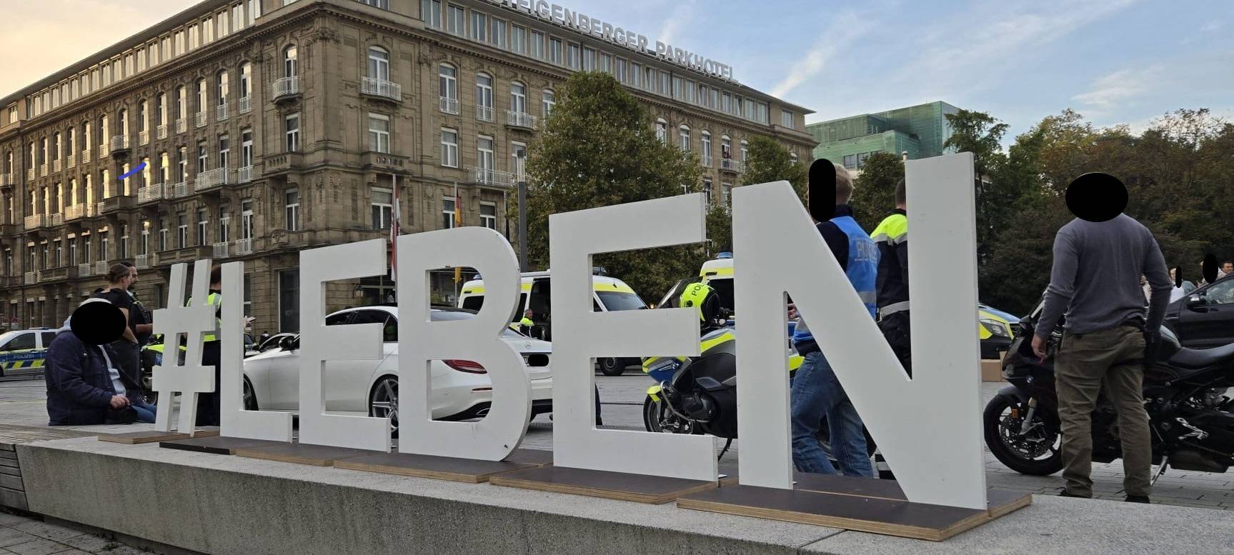 Ein Schild mit großen Buchstaben zeigt den Schriftzug #LEBEN. Aufgenommen auf dem Corneliusplatz.