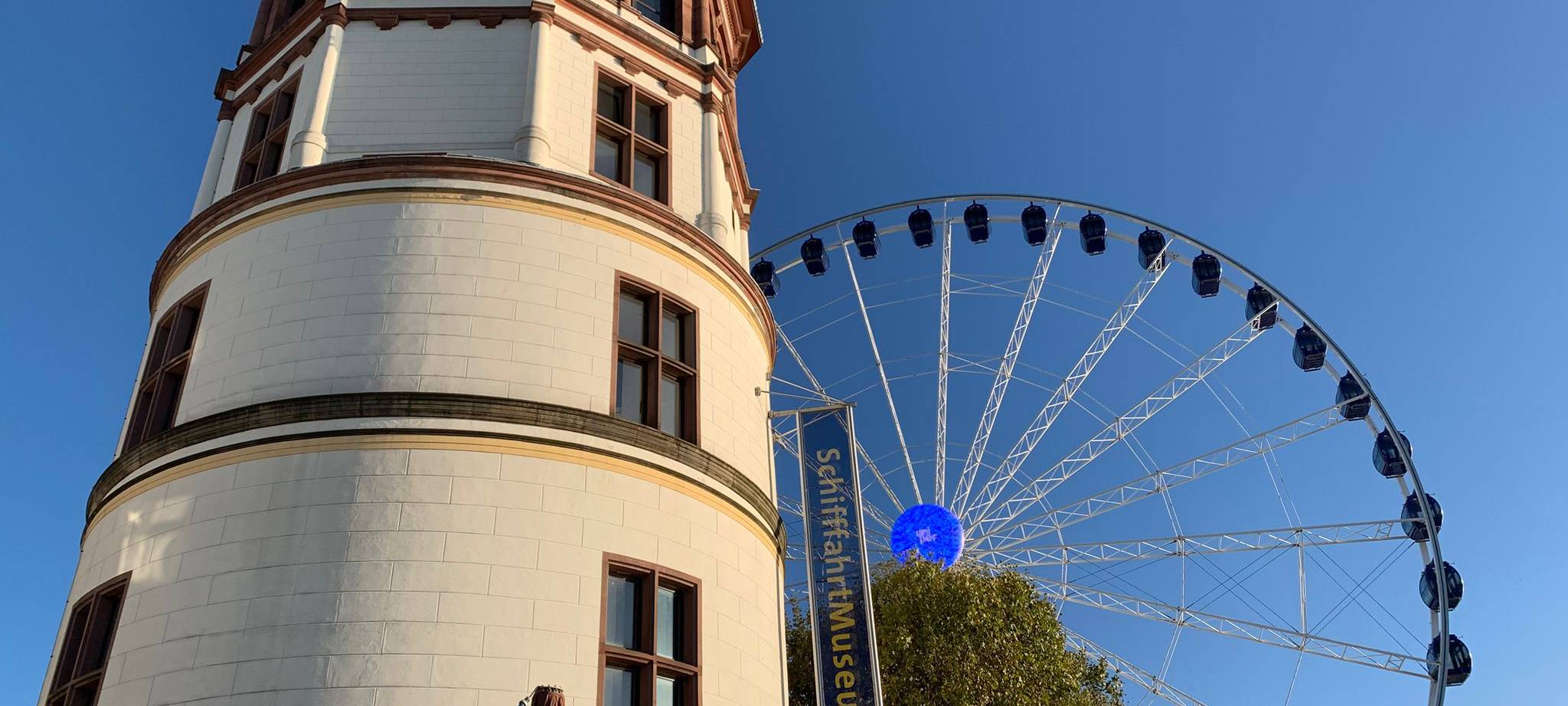 Schlossturm auf dem Burgplatz mit Riesenrad im Hintergrund.