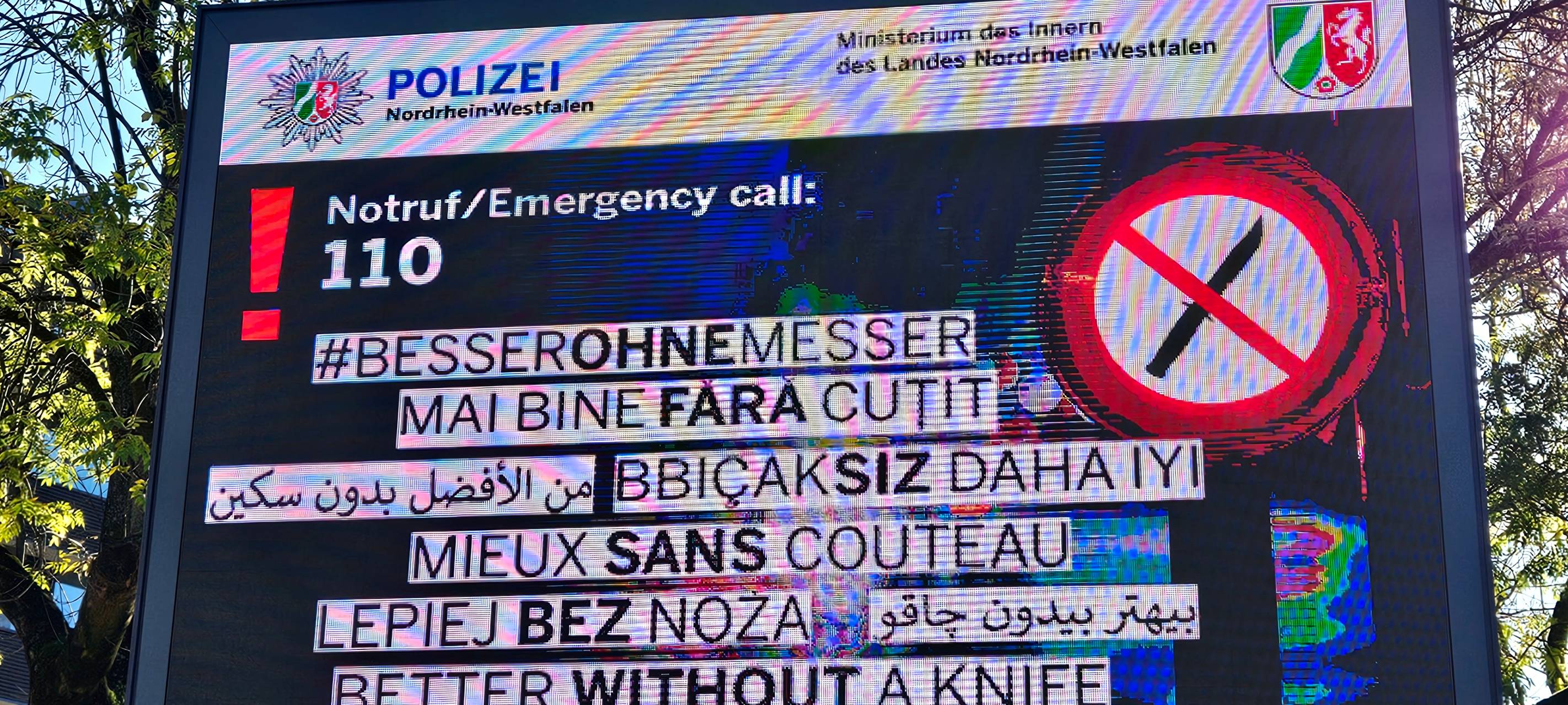 Plakat mit dem Solgan "BesserOhneMesser" in neun verschiedenen Sprachen.