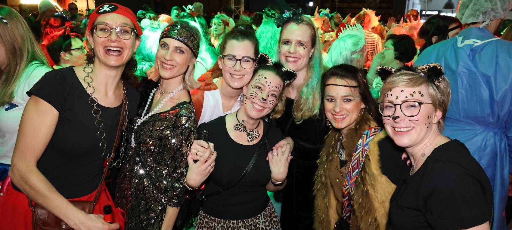 Ausgelassene Stimmung bei einer Altweiber-Party. Die Gruppe ist vergnügt und lächelt verkleidet in die Kamera.