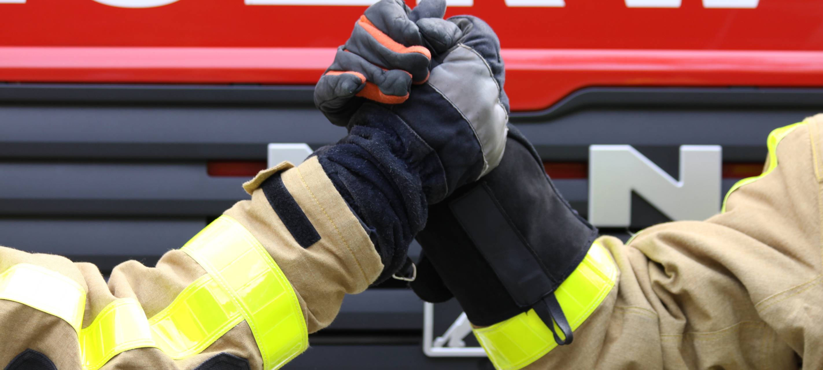 Zwei Feuerwehrleute machen einen Handshake.