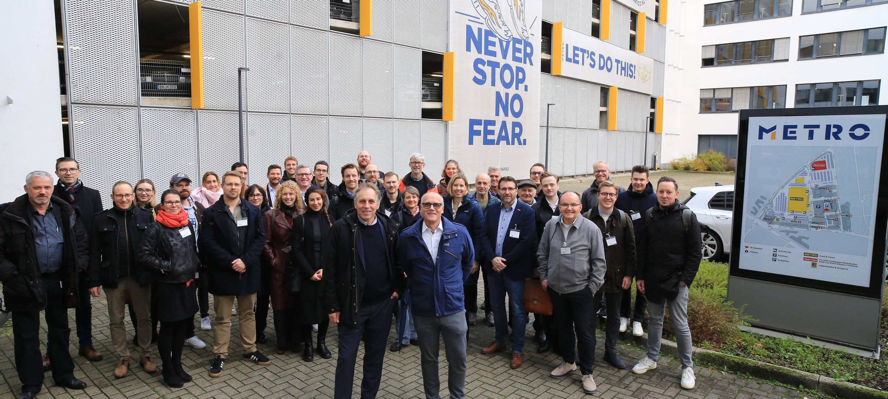 Beim Netzwerktreffen der Düsseldorfer Mobilitätspartner stehen Vertreter der Firmen und Umweltdezernent Jochen Kral vor der METRO.