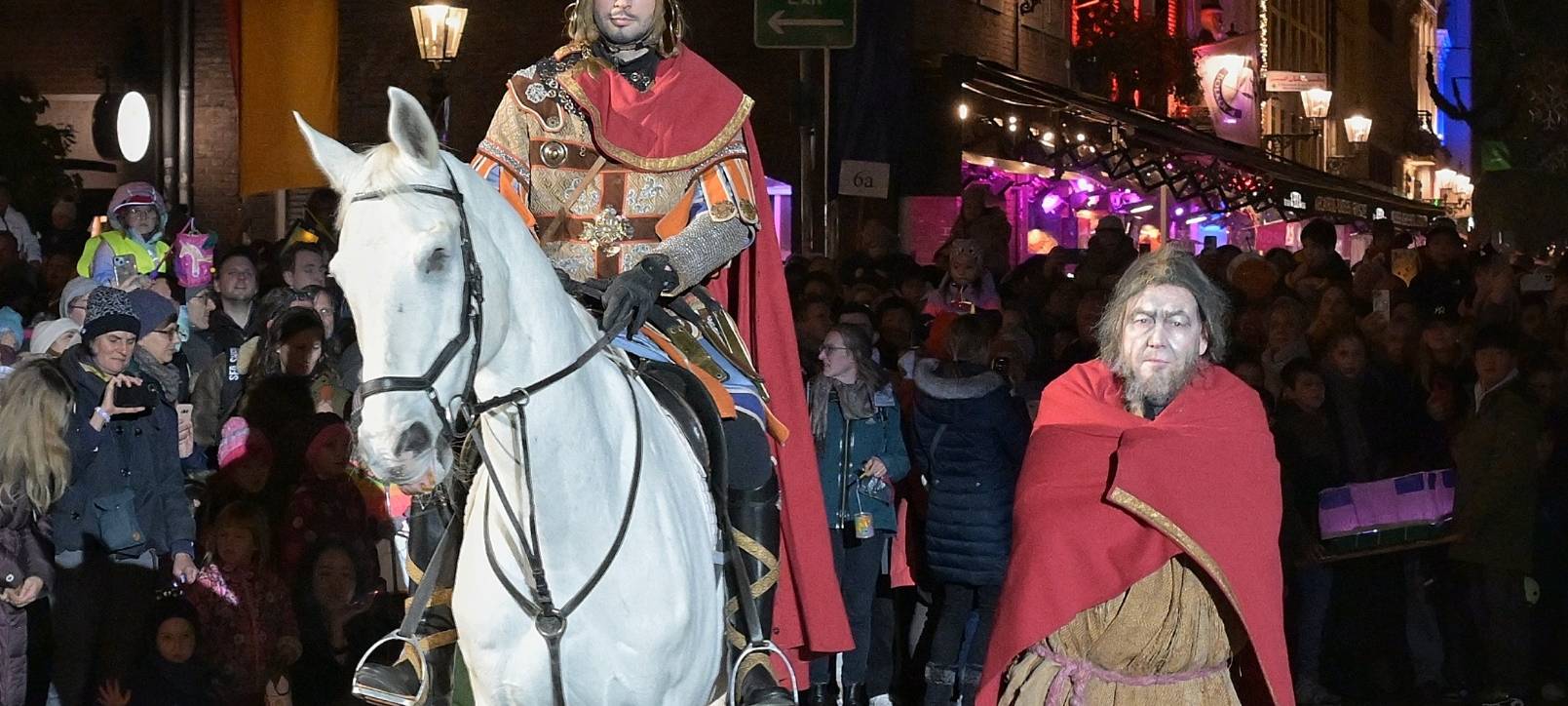 St. Martin hat seinen Mantel mit einem armen Mann geteilt. Der Marktplatz ist voller Menschen.