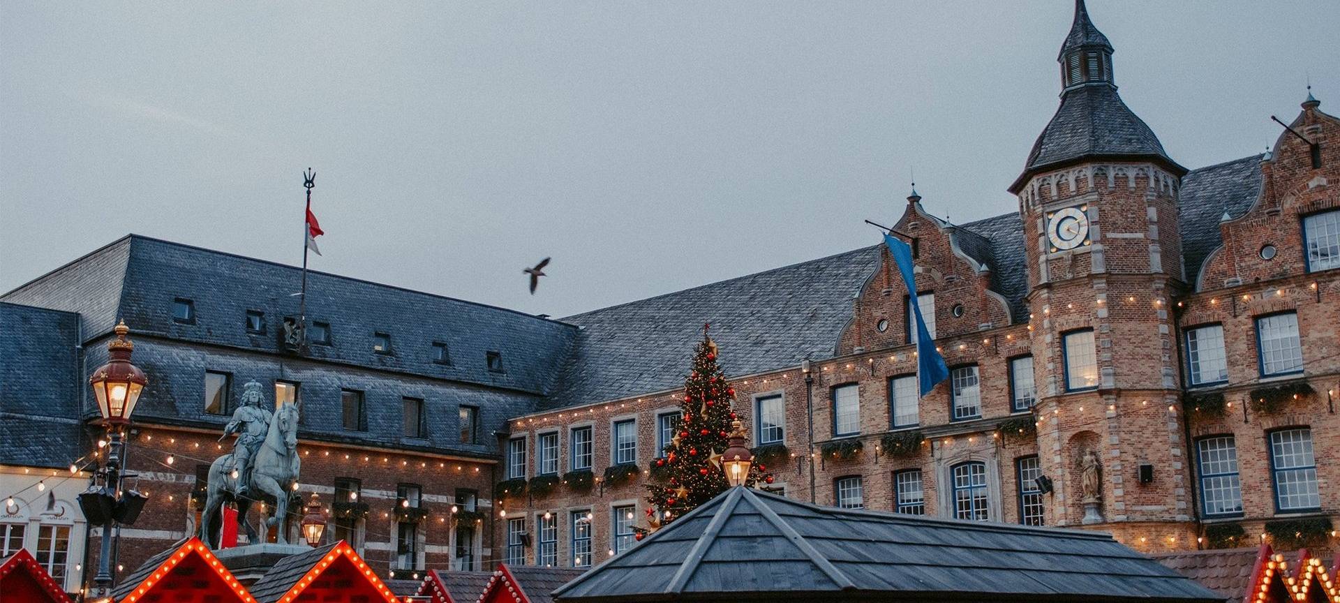 Weihnachtsmärke Überblick: Der Handwerkermarkt auf dem Marktplatz. Die Buden stehen direkt vor dem Rathaus und im Schatten von Jan Wellem.