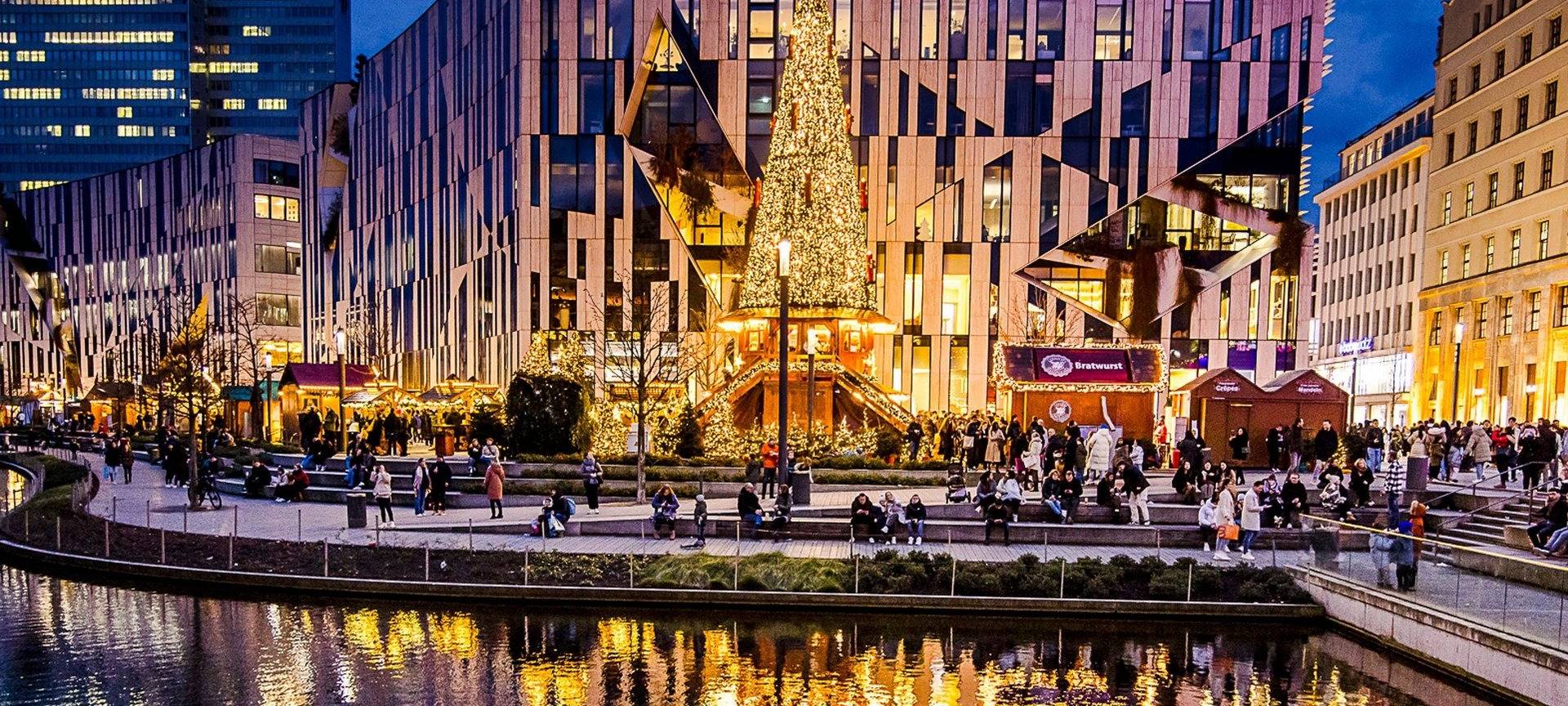 Weihnachtsmärke Überblick: Der Weihnachtsmarkt rund um den Kö-Bogen II. Die Buden sind beleuchtet und verströmen eine weihnachtliche Stimmung.