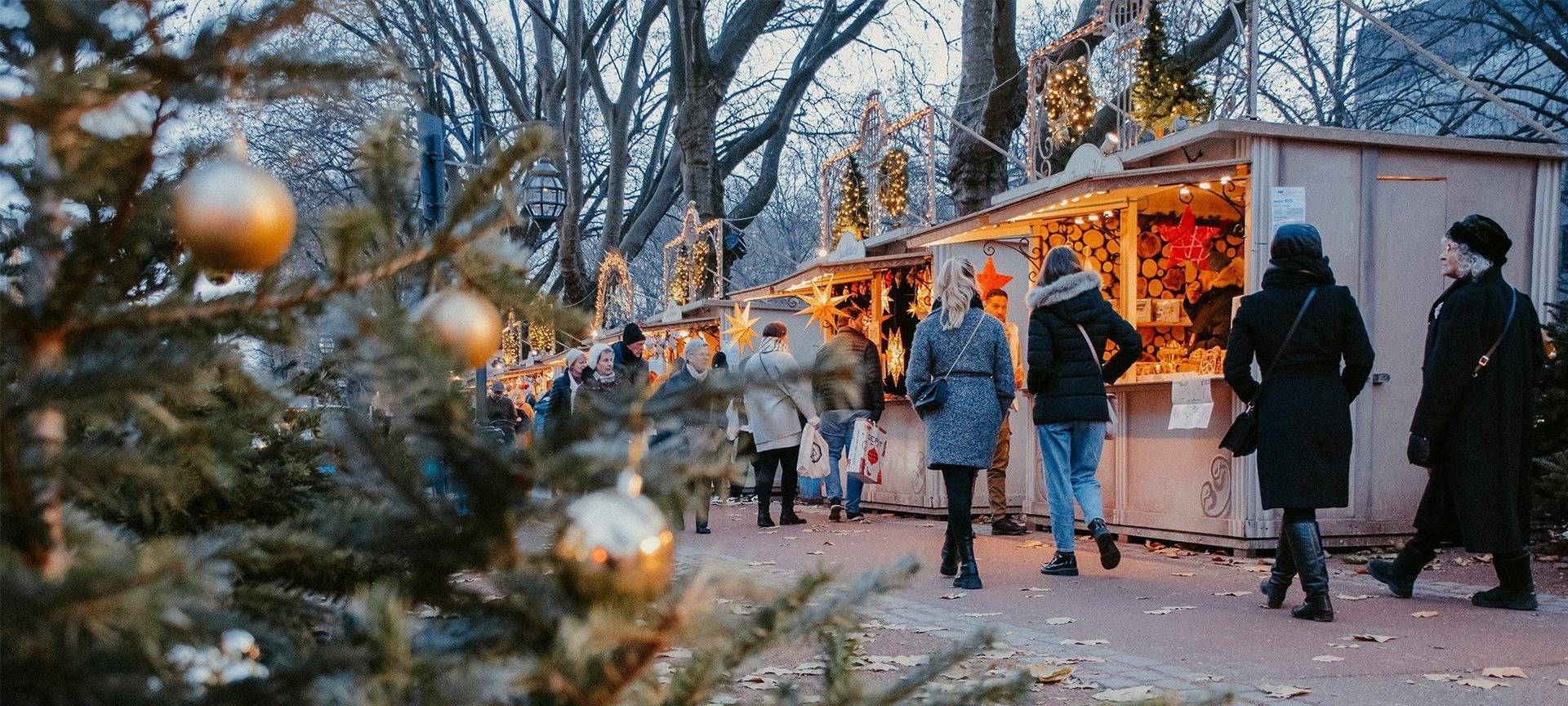 Weihnachtsmärke Überblick: Menschen schlendern über die Königsallee. Entlang der Buden des Kö-Lichtermarktes.