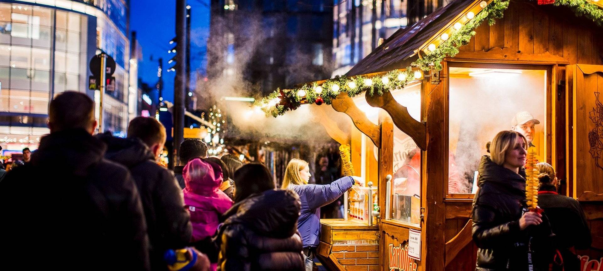 Weihnachtsmärke Überblick: Der Weihnachtsmarkt auf der Schadowstraße. Mit Buden und Menschen, die an den Buden entlang schlendern.