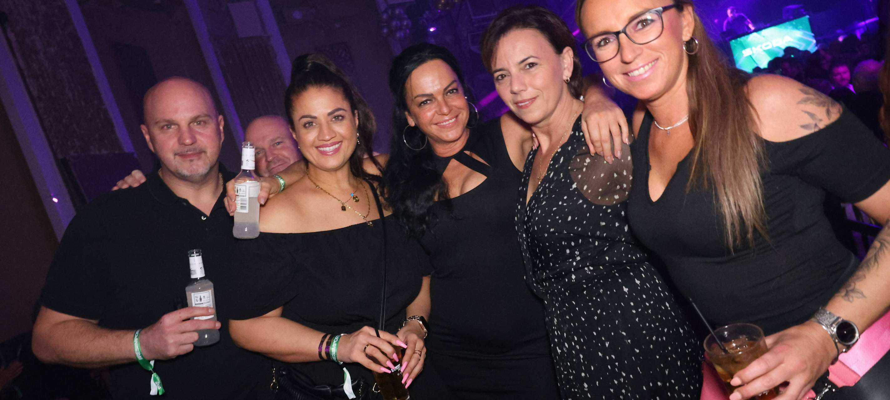 Ein Herr (links) und vier Damen posieren gemeinsam für ein Foto in der Nachtresidenz. Vier von ihnen halten Getränke in den Händen. Sie umarmen sich.