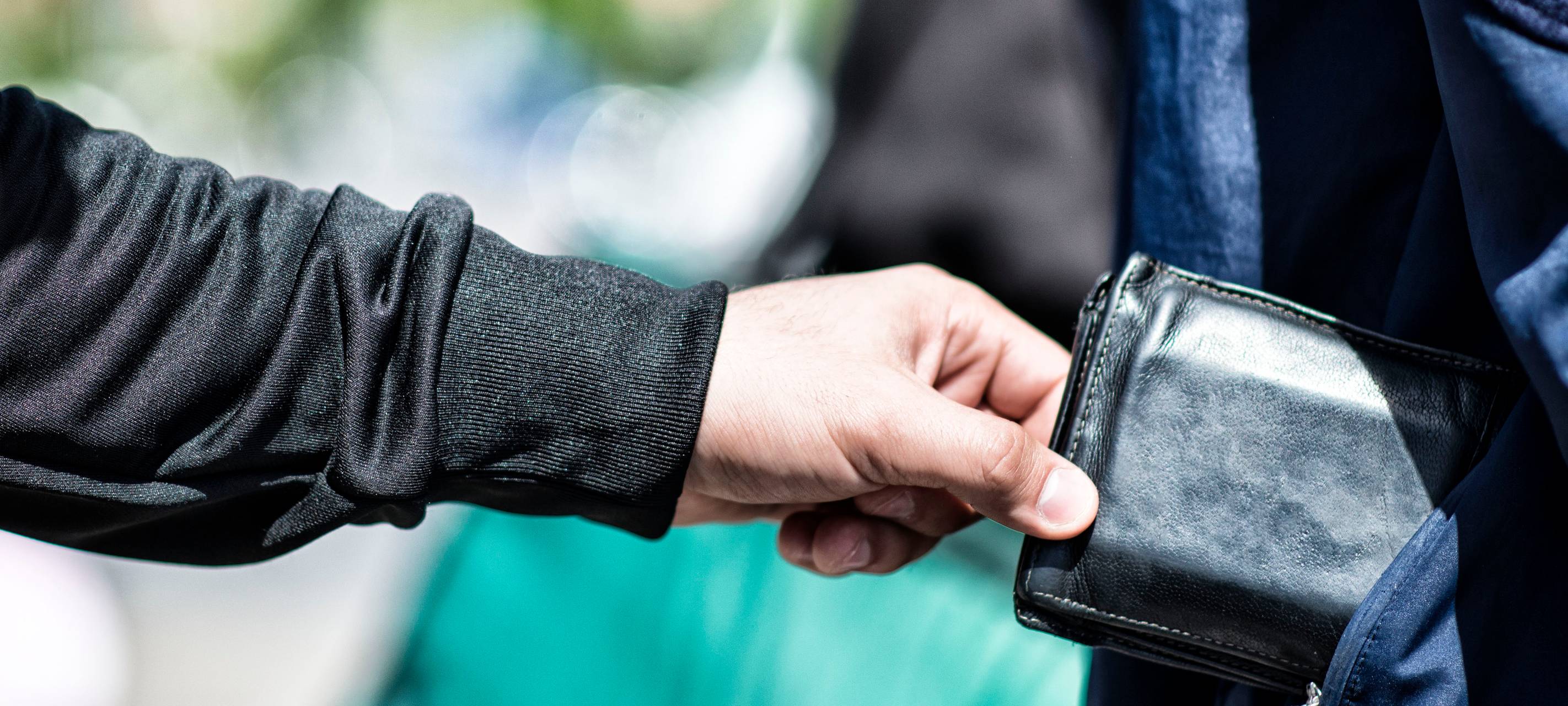 Ein Taschendieb entwendet eine Geldbörse aus einer Tasche
