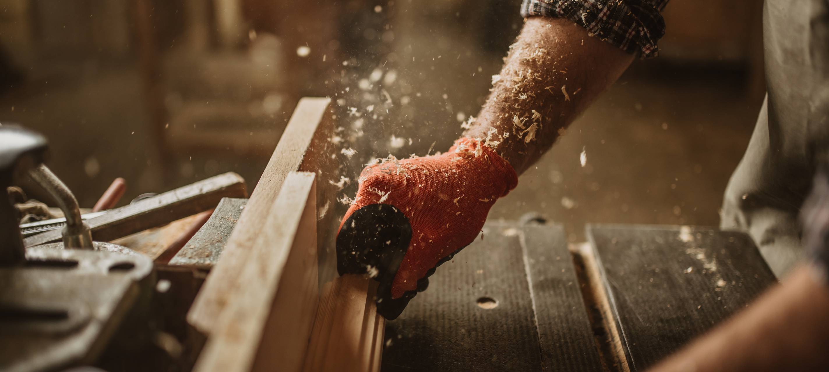 Ein Tischler arbeitet mit manuellem und elektrischem Werkzeug.