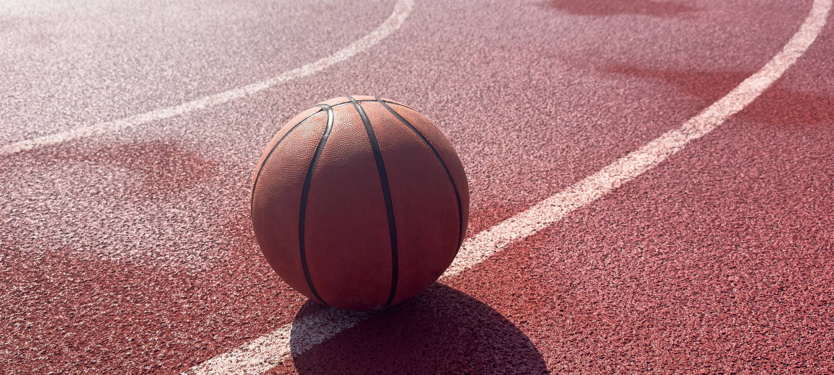 Ein Basketball liegt auf einem Basketball-Court.