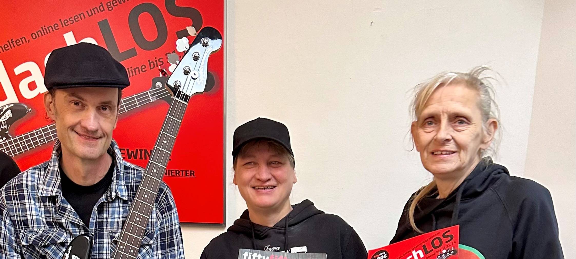 Breiti von den Toten Hosen mit Gitarre und Miriam mit fiftyfifty-Zeitung sowie Gisa mit dem Obdach-LOS.