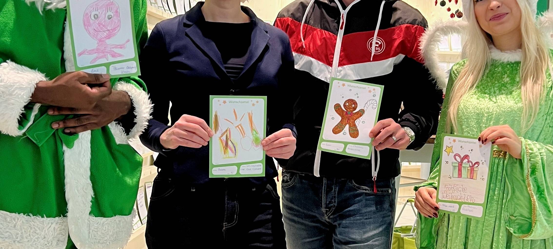 Ein grüner Weihnachtsmann und -engel im Look der Stadtwerke Düsseldorf eröffnen das Weihnachtswerk in den Schadow Arkaden. Mit dabei Bürgermeisterin Clara Gerlach und Ex-Fortunaprofi Axel Bellinghausen.
