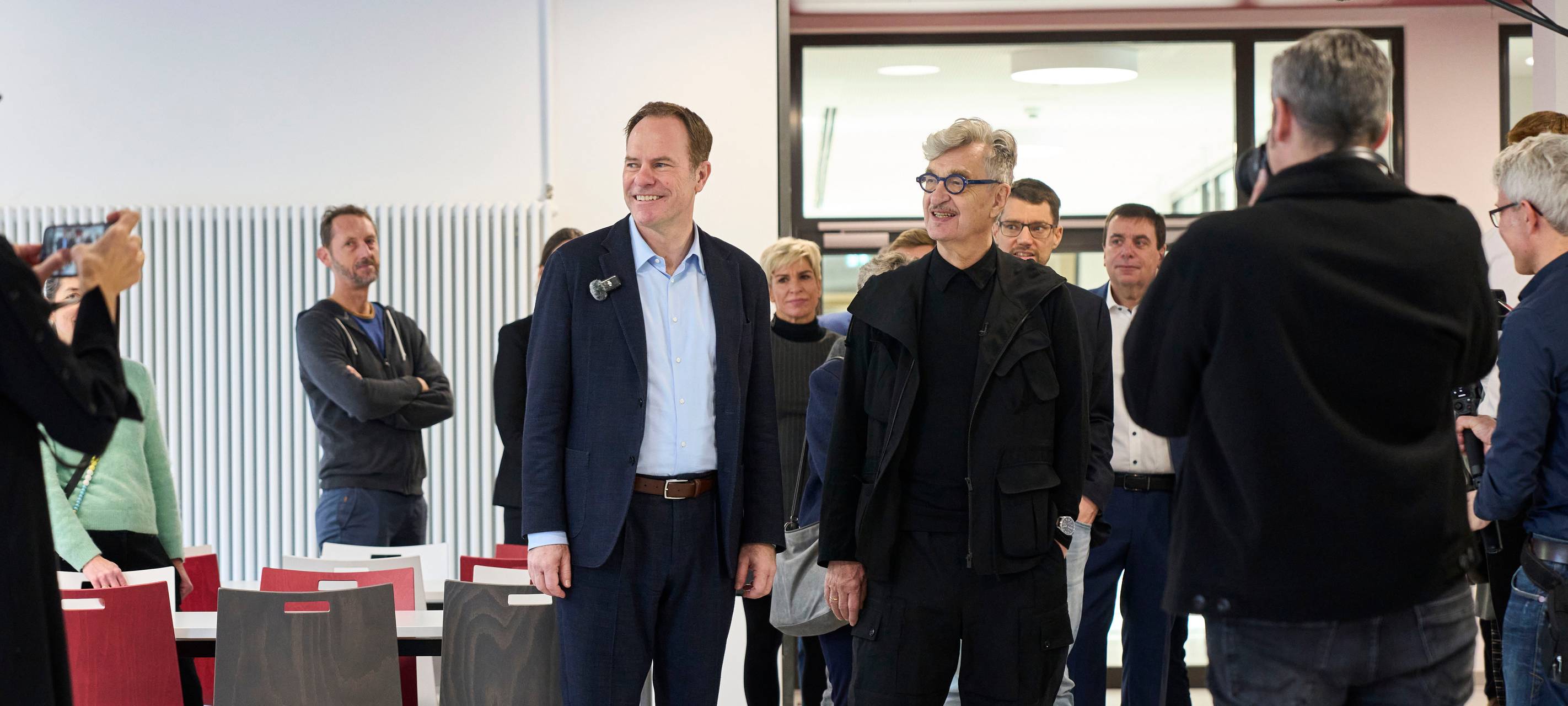 Wim Wenders schaut sich gemeinsam mit Oberbürgermeister Stephan Keller den Neubau des Wim-Wender-Gymnasiums an.
