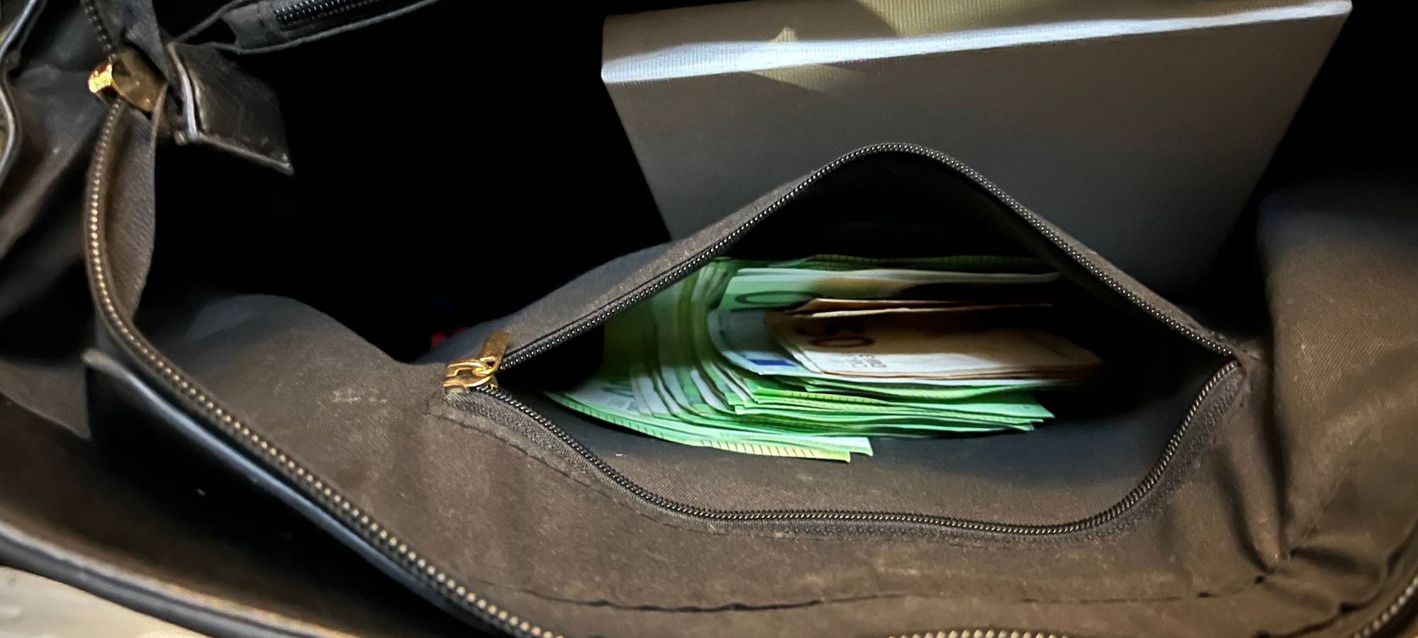 Diebesgut nach Wohnungseinbruch. Zu sehen ist Bargeld, das in einer Handtasche steckt. Es sind hauptsächlich 100€-Scheine.