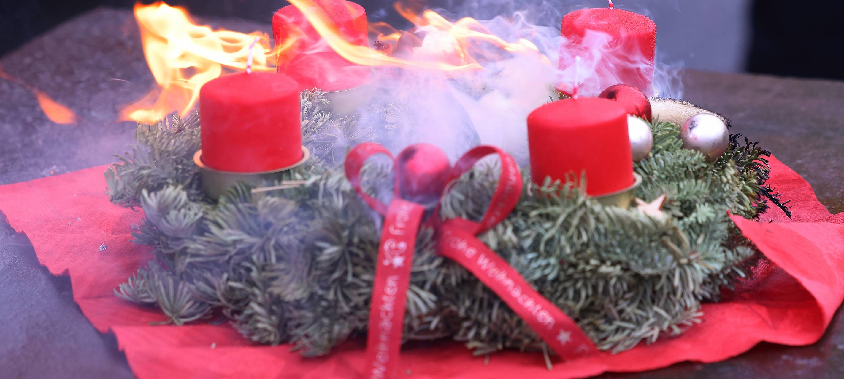 Feuer gefangen: Ein Adventskranz mit roten Kerzen und Deko in Flammen.
