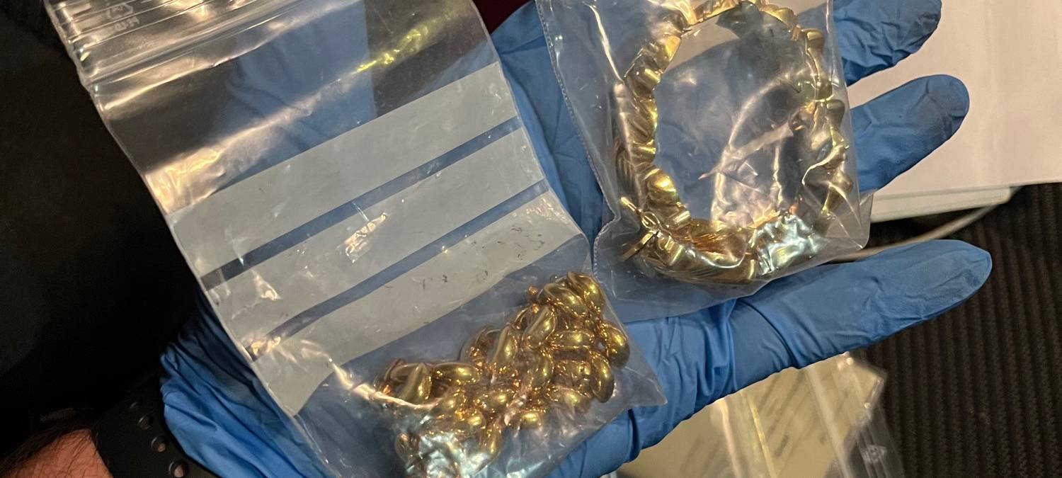 Diebesgut nach Wohnungseinbruch. Zu sehen ist eine Hand, die eine Kette und Schmuck in Plastiktüten präsentiert..