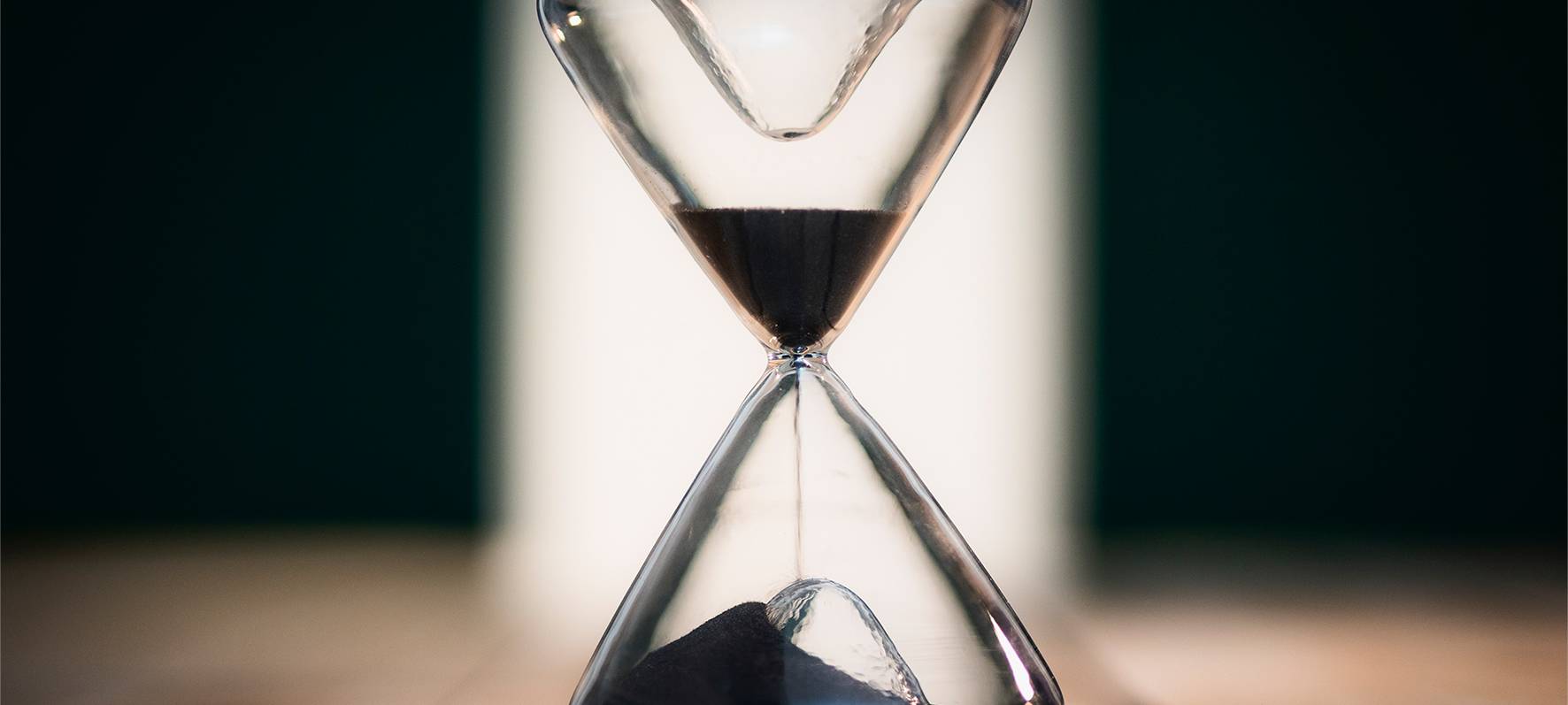 Eine Sanduhr symbolisiert Zeitarbeit und befristete Jobs und Arbeitsverträge.