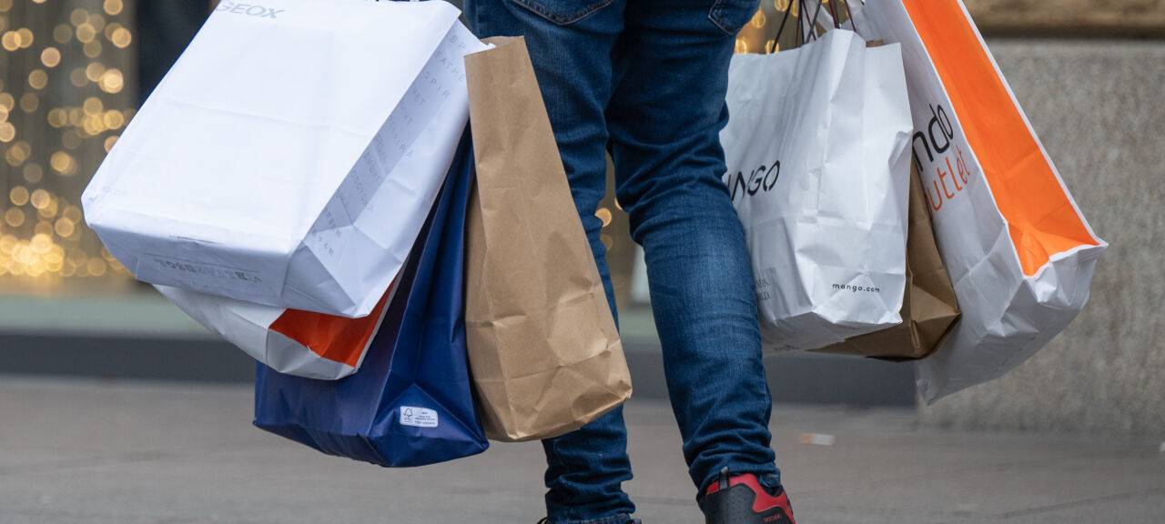Ein Mann trägt viele Einkaufstaschen nach einer Shoppingtour